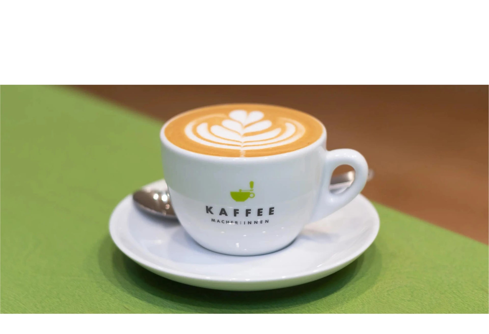 Das Bild zeigt eine gefüllte Kaffeetasse mit Latte Art