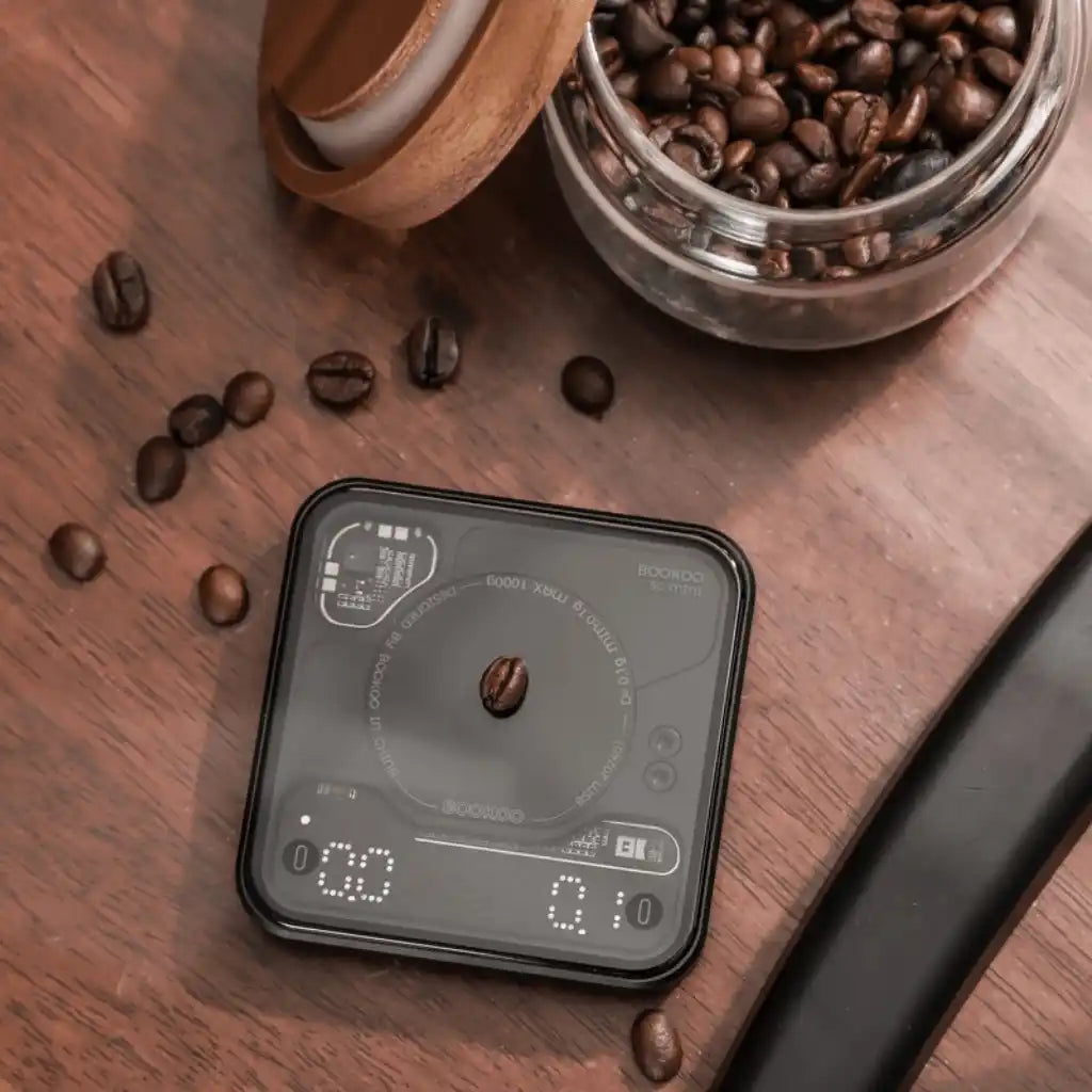 BOOKOO THEMIS Mini auf einem Tisch mit Kaffeebohnen