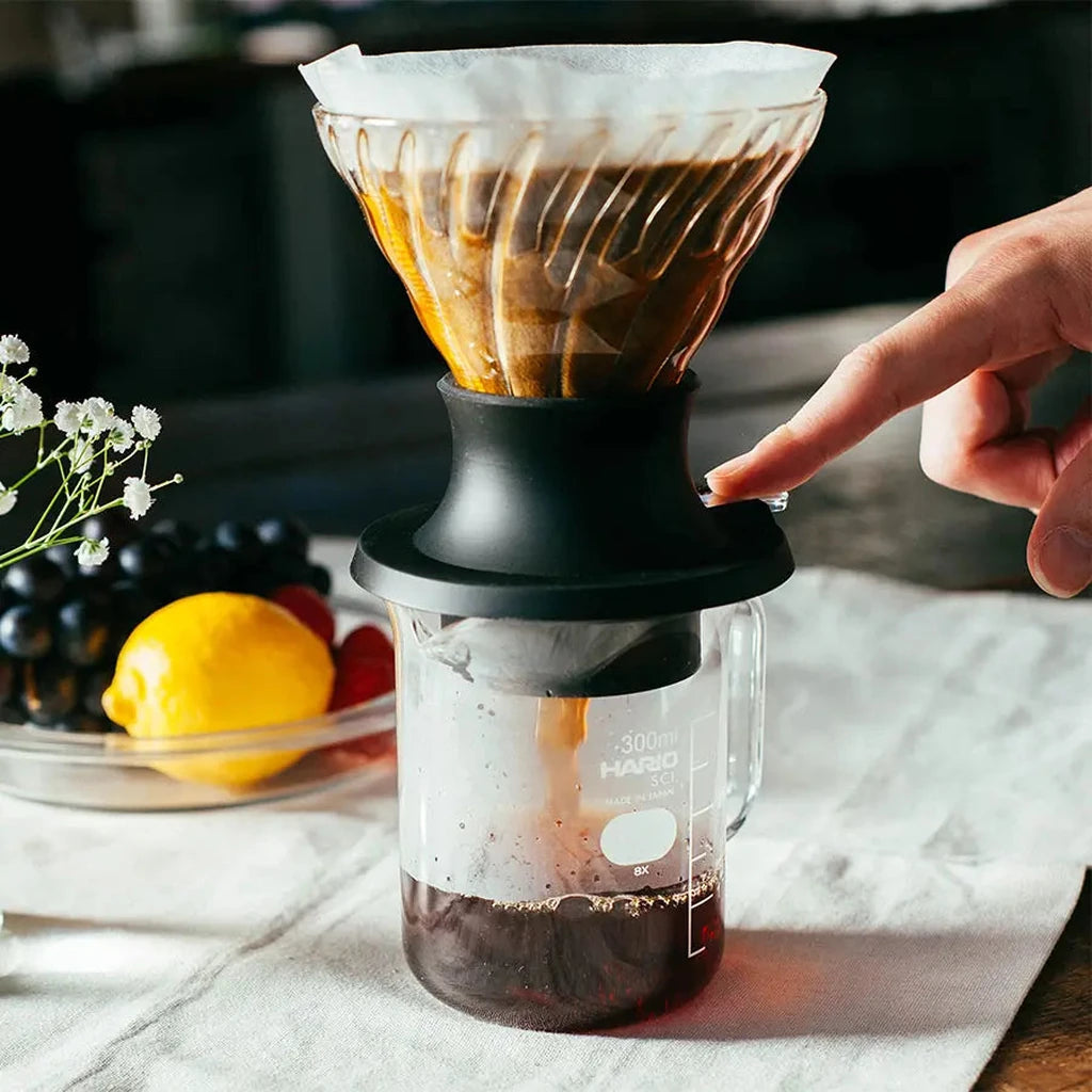 Hario Switch Immersion-Dripper auf Tisch, Zeigefinger auf Dripper