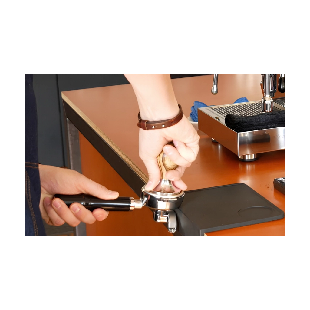 Kaffeemacher Tamping-Matte mit Winkel in Schwarz bei der Anwendung mit Siebträger und Tamper auf der Arbeitsplatte